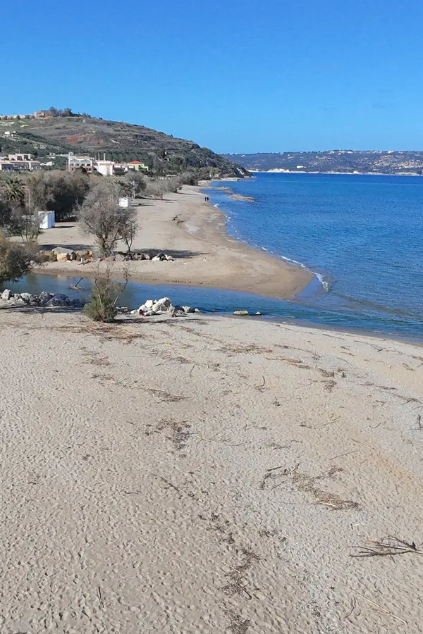 White sandy beach and clear turquoise waters defining Kiani Akti Beach on the Cretan coast.